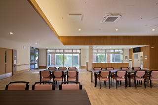 特別養護老人ホーム姫見苑の食堂談話機能訓練室。中庭に面したこの広い空間は、入居者の生活の中心となるスペースの為、明るく開放的な雰囲気の室内空間。ホスピタリティを重視した空間。